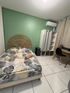 a bedroom with a bed in a room with a desk at Appartement 3 chambres récemment rénové in Les Abymes