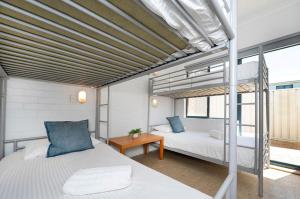 a bedroom with two beds and a table at Windsurfer Beach Chalet 4 in Lancelin