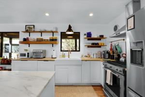 a kitchen with white cabinets and a counter top at Red Bird Cottage in Wimberley