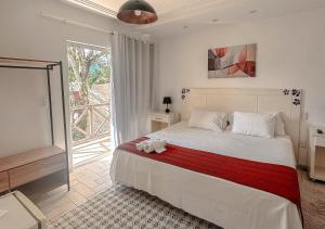 a bedroom with a bed with a stuffed animal on it at Pousada Flor de Penedo in Penedo +74 photos