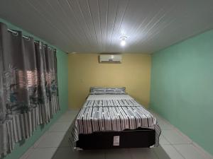 a bedroom with a bed in a room at Quarto Ilha do amor in Santarém
