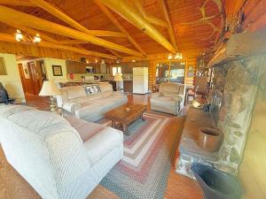 a living room with couches and a stone fireplace at 12 Mile Ranch in Custer