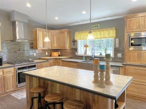 a kitchen with wooden cabinets and a large island with stools at Battle Creek Station in Keystone