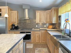 a kitchen with wooden cabinets and stainless steel appliances at Battle Creek Station in Keystone +16 photos