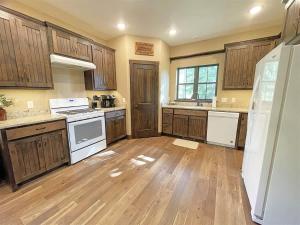 a large kitchen with wooden cabinets and white appliances at Bishop Mountain Lookout in Hill City