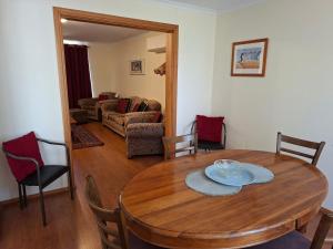 a dining room with a table and a living room at Swallows Nest in Cape Bridgewater