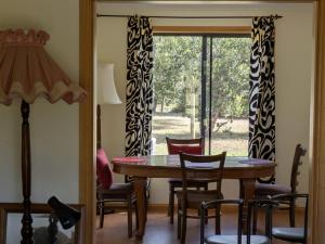 a dining room with a table and chairs and a window at Swallows Nest in Cape Bridgewater