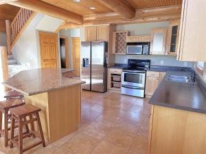 a large kitchen with a stove and a refrigerator at Cottage at Storm Mountain #3 in Hill City