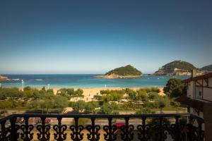 uma vista para a praia a partir de uma varanda em La Galería em San Sebastián