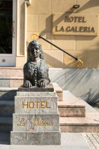 a statue of a woman in front of a hotel at La Galería in San Sebastián