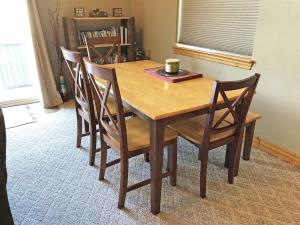 a wooden table with four chairs and a cup on it at Cottage at Storm Mountain #5 in Hill City