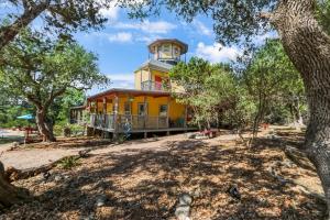 a yellow house with a clock tower on top of it at Canyon Lake Lighthouse in Canyon Lake