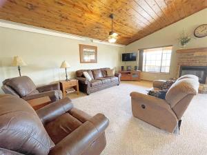 a living room with leather furniture and a fireplace at Gold Mill in Hill City