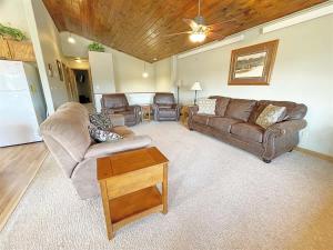 a living room with two couches and a table at Gold Mill in Hill City