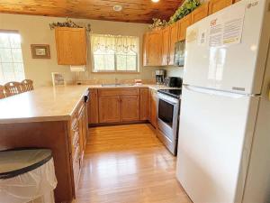 a kitchen with a white refrigerator and wooden cabinets at Gold Mill in Hill City