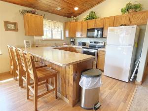 a kitchen with a white refrigerator and wooden cabinets at Gold Mill in Hill City