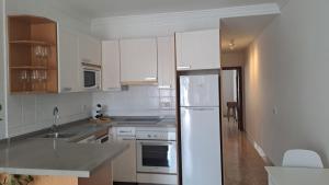 a kitchen with white cabinets and a white refrigerator at Iris 25 in Playa Blanca