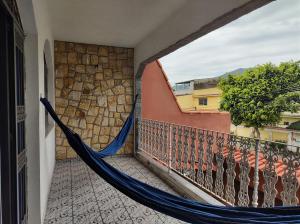 a hammock on a balcony of a building at Casa No Rio Garagem Wi-Fi Próximo Praia Barra in Rio de Janeiro