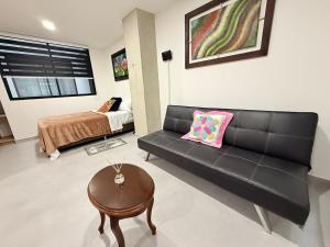 a living room with a black couch and a bed at Total Comfort Studio Santa Rosa in Santa Rosa de Cabal