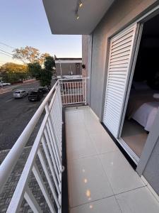 a balcony of a building with a bed and a street at Uruguaiana House in Uruguaiana