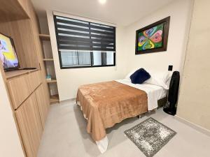 a bedroom with a bed with a television and a window at Total Comfort Studio Santa Rosa in Santa Rosa de Cabal