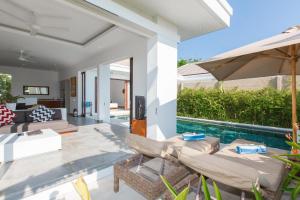 una sala de estar con piscina y una villa en Gajah Villas Bali by Nagisa Bali, en Seminyak