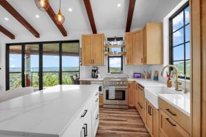 a kitchen with white countertops and large windows at Canyon Tree House in Canyon Lake