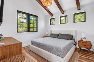 a bedroom with a bed and two windows at Canyon Tree House in Canyon Lake