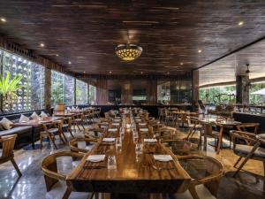 a dining room with wooden tables and chairs at Peppers Seminyak in Seminyak