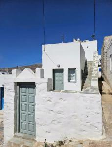a white building with two green doors on it at Meltemi Chora Amorgos in Amorgos