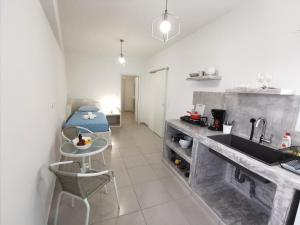 a kitchen with a sink and a table and a couch at Meltemi Chora Amorgos in Amorgos +5 photos