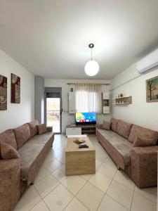 a living room with two couches and a tv at Beach Apartments Durres in Durrës