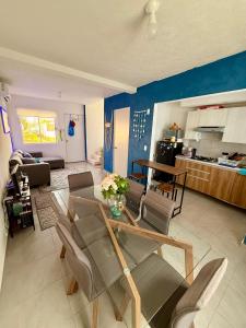 a living room with a table and chairs and a kitchen at La casa Azul in Acapulco
