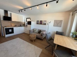 a living room with a table and a kitchen at Neu - Ferienwohnung Allgäuparadies - Traumhafte Aussichten mitten in der Natur des Westallgäus in Oberreute