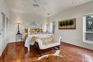 a bedroom with a bed and a chair and a fan at Casa Cielo in Wimberley