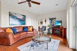 a living room with a leather couch and a tv at Casa Cielo in Wimberley