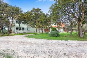 a gravel driveway in front of a white house at Casa Robles- The Bluebonnet in Wimberley