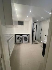 a bathroom with a washing machine and a sink at Sydney Homestay in Mölndal