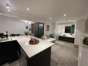 a living room with a kitchen and a living room with a couch at Sydney Homestay in Mölndal