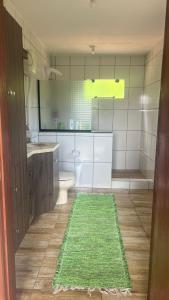a bathroom with a green rug on the floor at Recanto Colina in Picada Cafe +2 photos