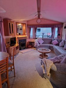 a living room with a couch and a table at BELLESVIEW Clarach Bay in Aberystwyth