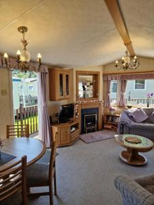 a living room with a couch and a table at BELLESVIEW Clarach Bay in Aberystwyth