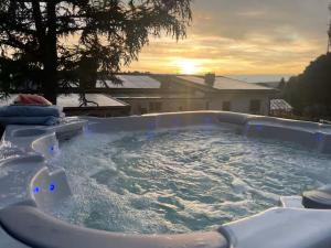 a jacuzzi tub with a sunset in the background at Sydney Homestay in Mölndal