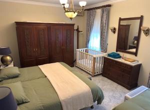 a bedroom with a bed and a crib and a mirror at La Casa de los Limones in Montilla +75 photos