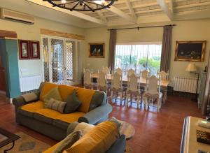 a living room with a couch and a table and chairs at La Casa de los Limones in Montilla