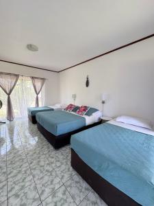 a bedroom with two beds and a window at Cabañas Honu Nui Inn in Hanga Roa