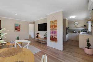 a living room with a table and a kitchen at Cowes Monash Hideaway in Cowes +6 photos