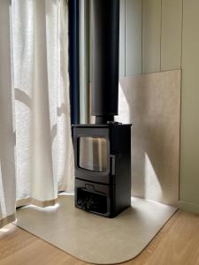 a black stove sitting in a kitchen next to a window at The Flower Sanctuary Tiny Home in Springbrook
