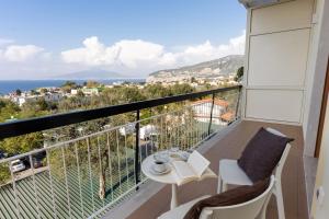 a balcony with a table and chairs and the ocean at Vanity Suite in Sorrento