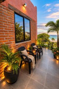 a patio with chairs and plants and a brick wall at Hugo's Place in Taganga
